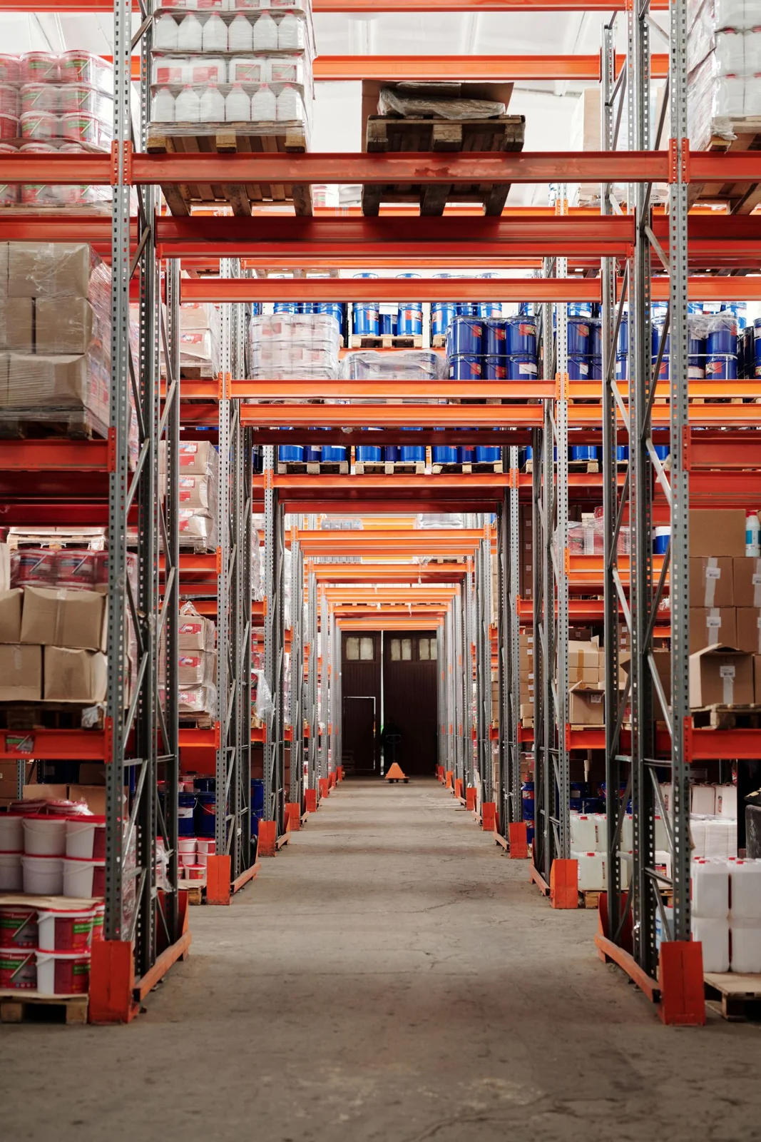 Warehouse aisle lined with tall shelves of stored goods